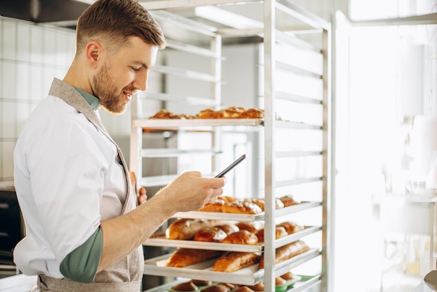 Padeiro na cozinha registrando uma transferência pelo celular